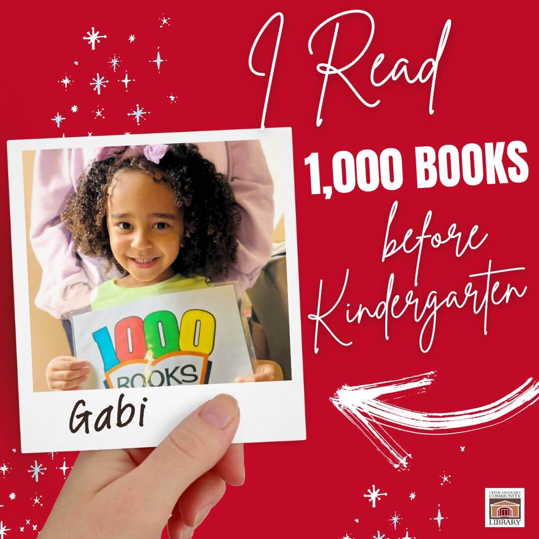 A hand holding a polaroid of a little Black girl smiling with a sign that says 1000 books. Text beside the photo says I Read 1,000 Books before Kindergarten.